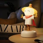 Cheerful cartoon lampe mit gelbem hut und rotem umhang für eine beruhigende atmosphäre